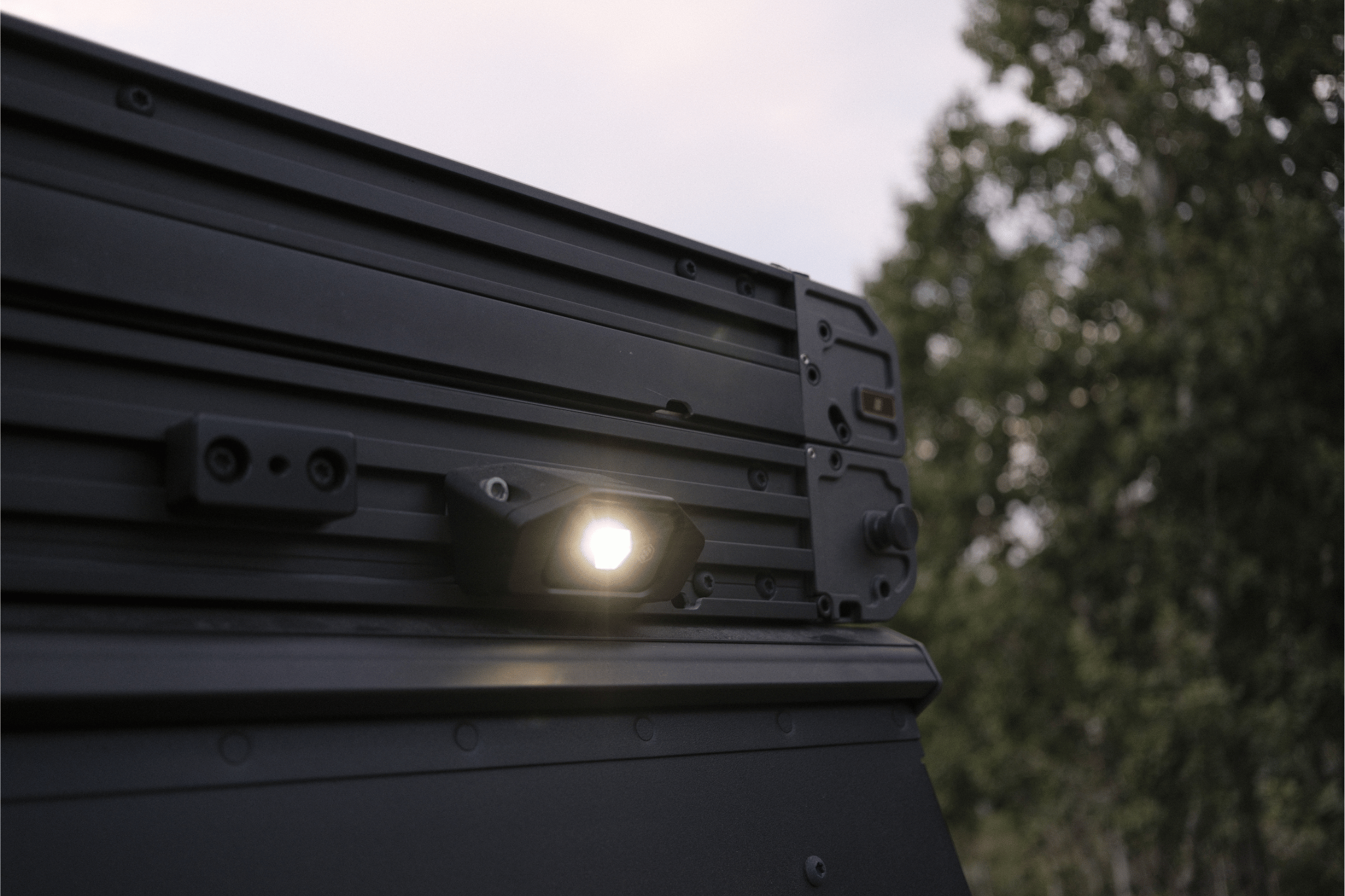 Light on a vehicle gfc camper with trees in the background