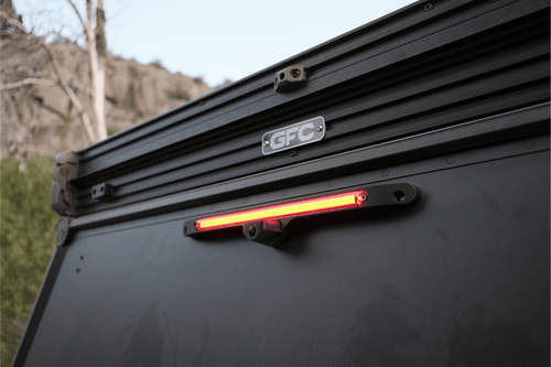 Black vehicle roof rack with LED light and 'GFC' branding against a natural background