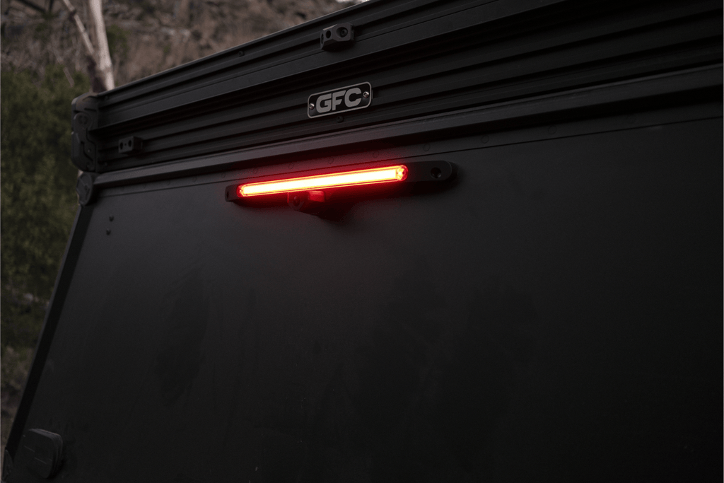 Tail light of a vehicle with 'GFC' branding in a dark setting